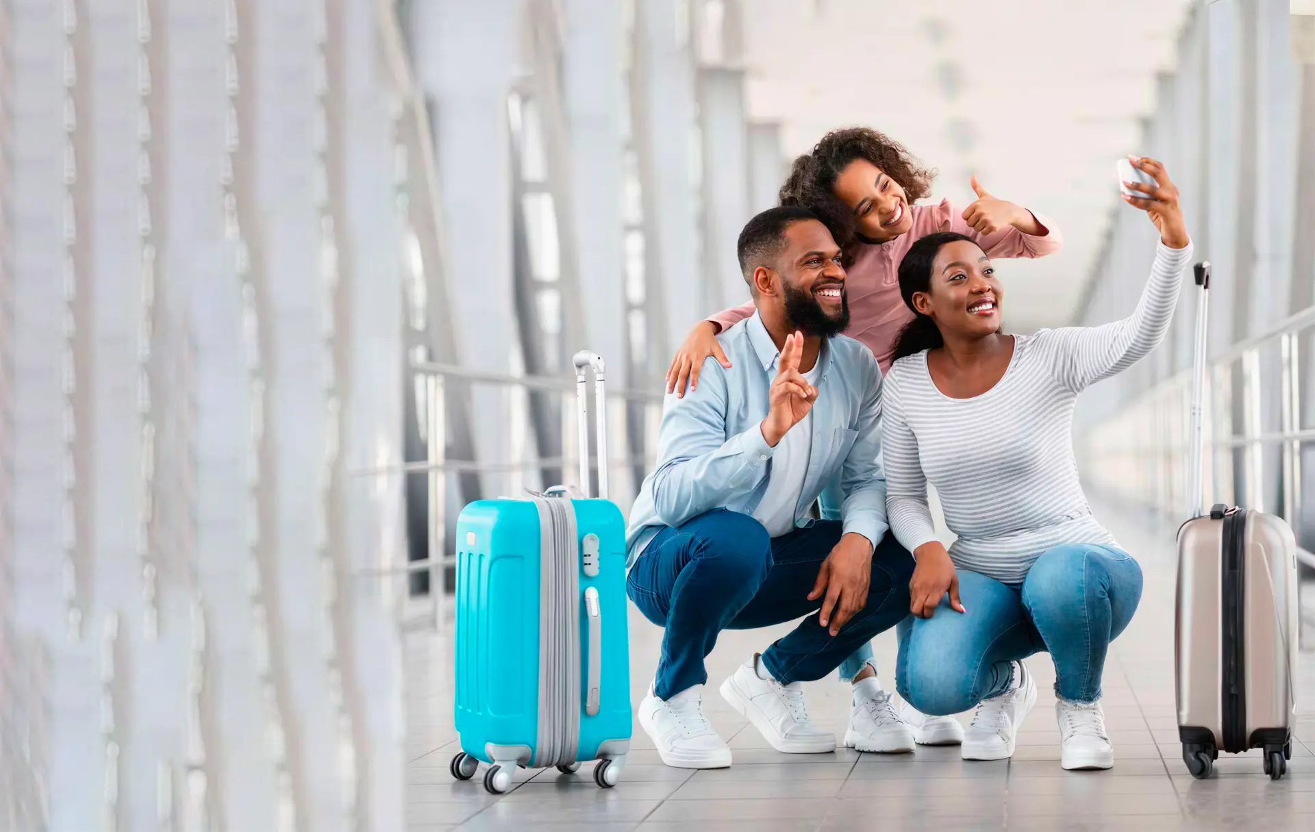 Família feliz num terminal de aeroporto, tirando uma selfie com malas de viagem