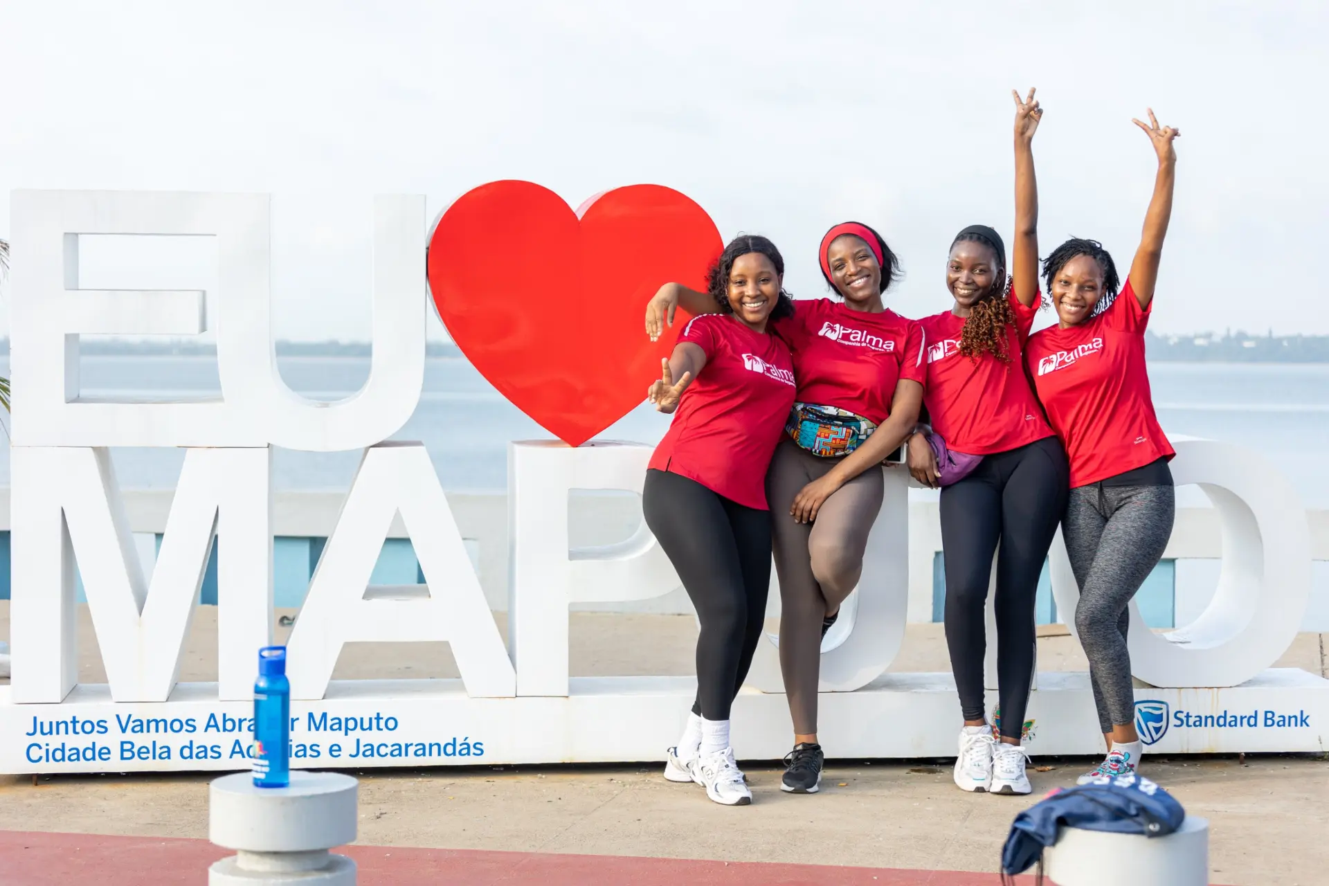 Colaboradoras da Palma Seguros junto ao letreiro Eu Amo Maputo