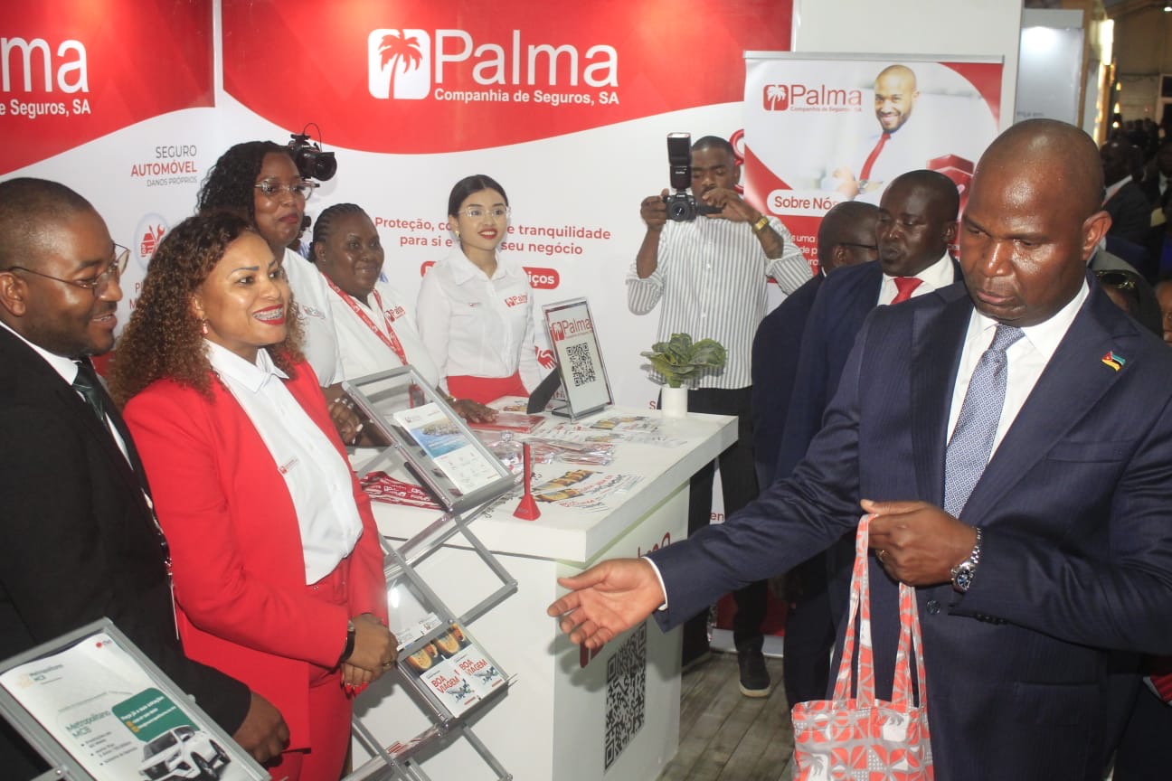 Entrega de sacola promocional da Palma Seguros a visitante oficial no stand da FACIM 2026